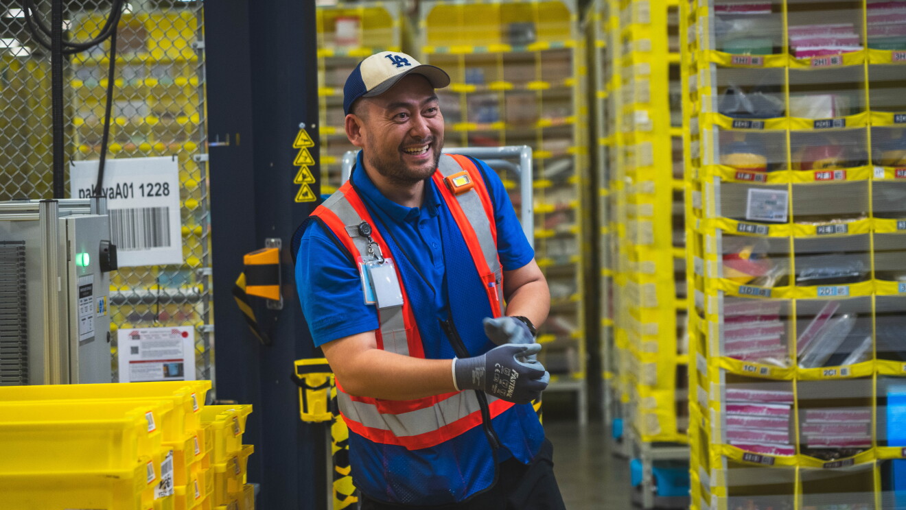 Amazon warehouse employee smiling wearing a vest