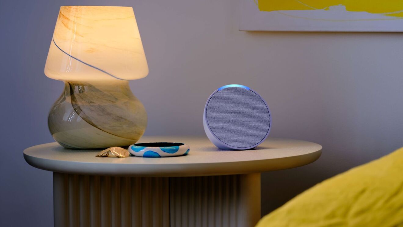 Bedside table with stylish lamp, Echo smart speaker, and personal items