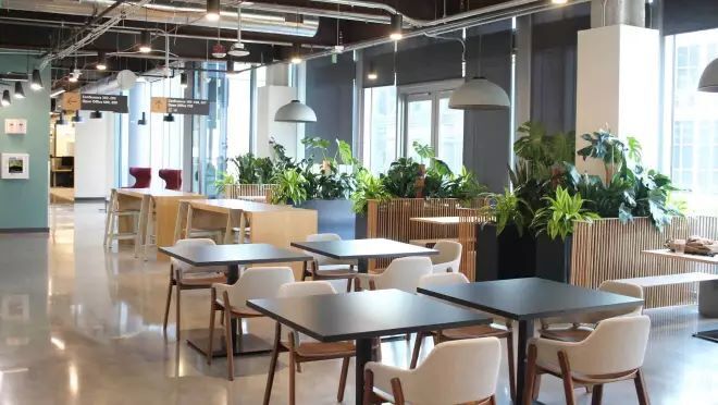 明るいロビーにミニマルなデザインの椅子やテーブルなどが並べられている