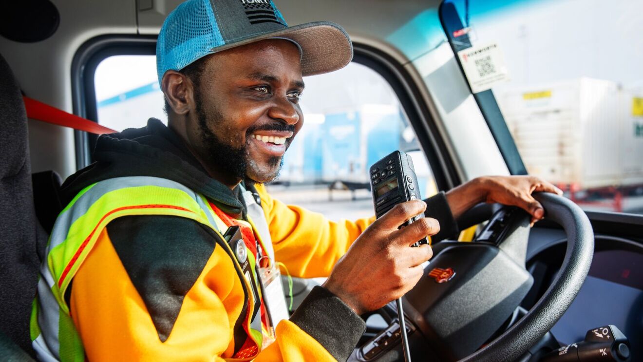Truck driver in safety vest at the wheel