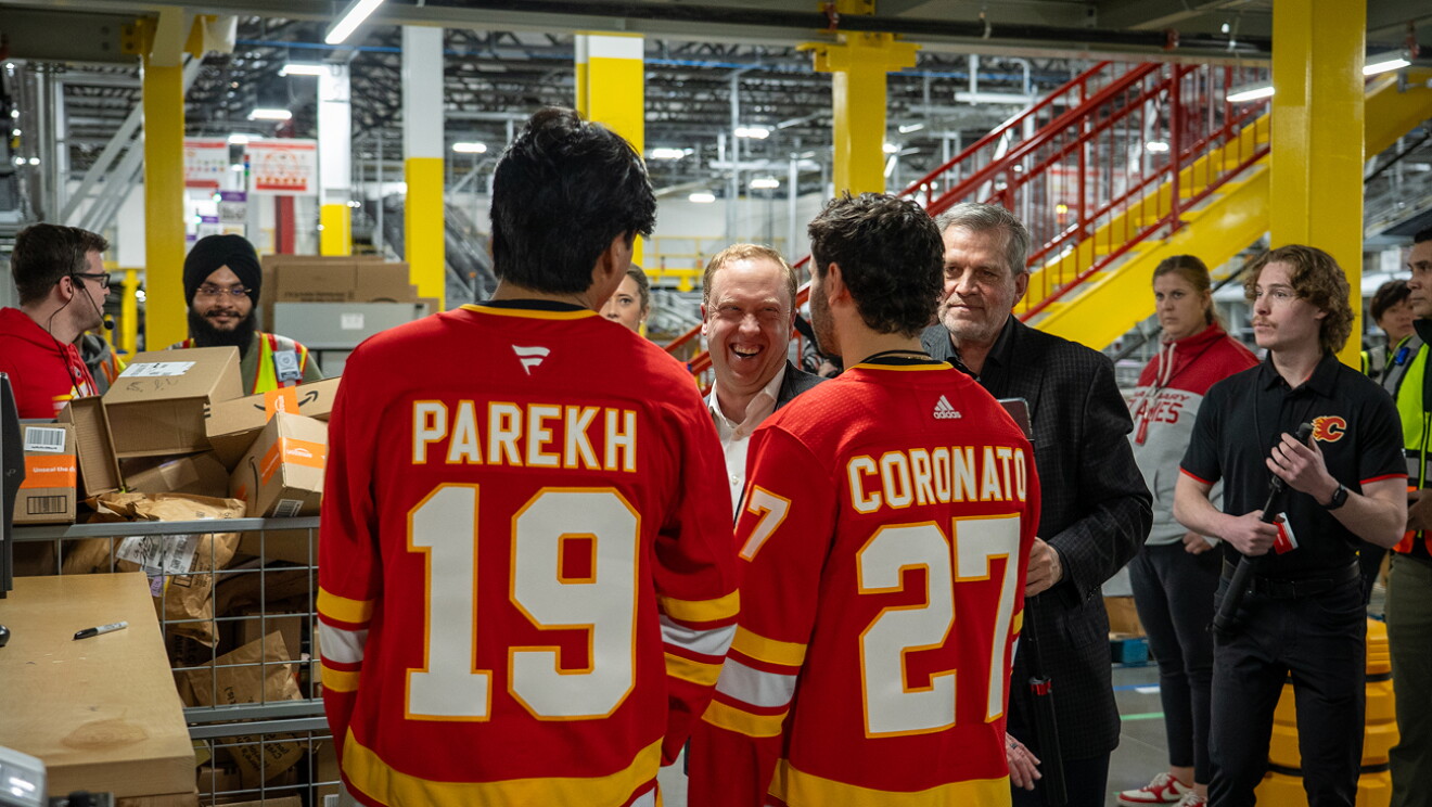 Two Calgary Flames hockey players packing and shipping Amazon boxes