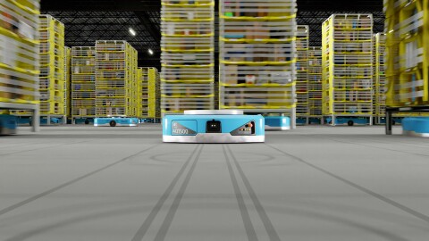 線が引かれている灰色の床の中央に水色の平らなロボット。その後ろに黄色い商品棚を載せた同じ形の水色のロボットが十数台見える