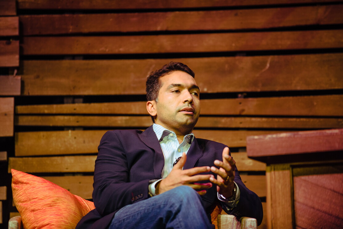 A man, Maju Kuruvilla, is seated on stage during Amazon "Live at the Ryman" event.