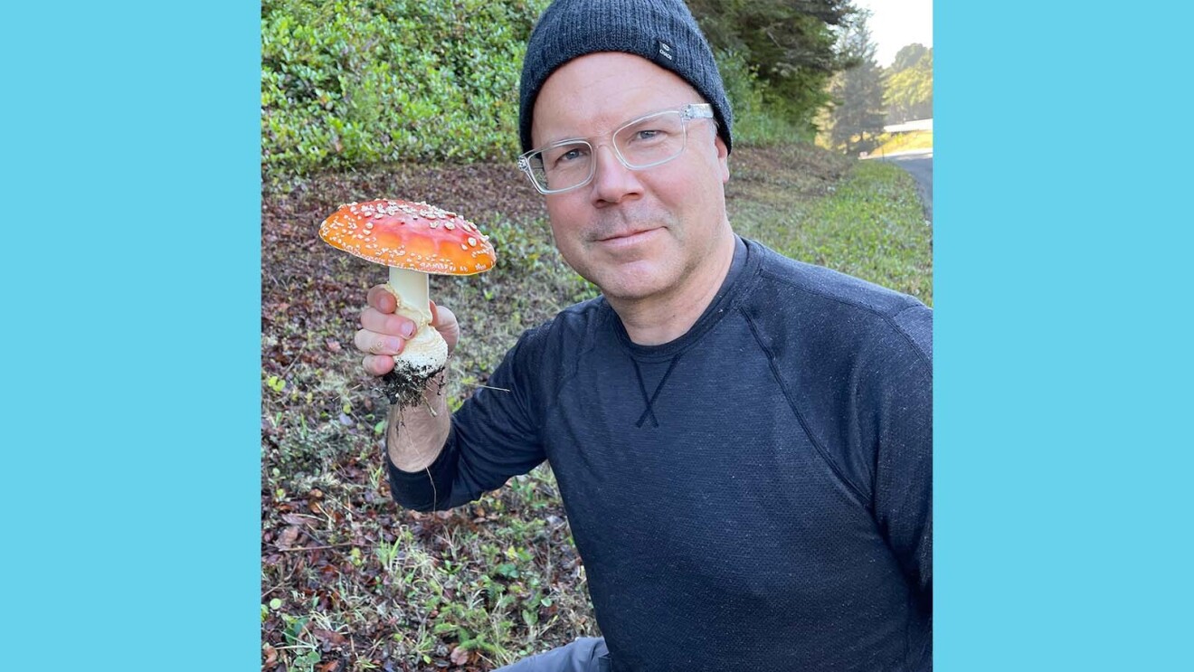 David on a walk holding a large Death Cap mushroom in his hand.