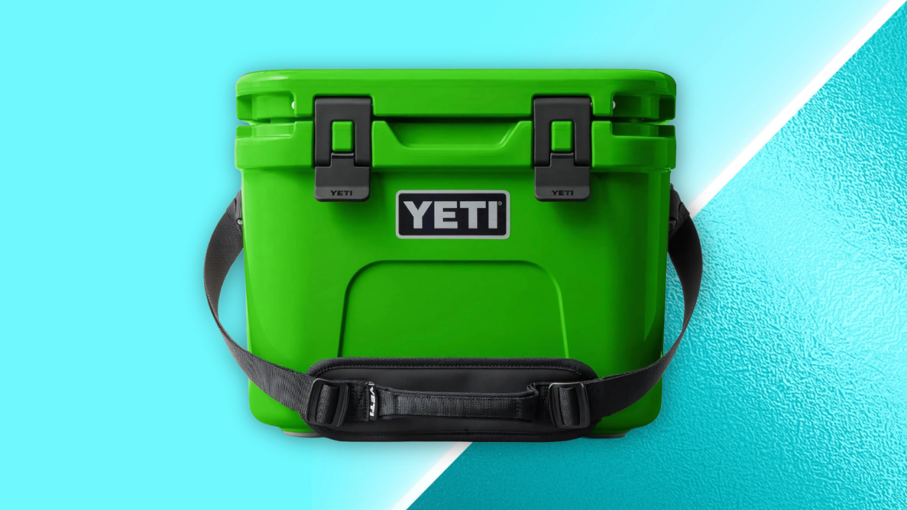 Bright green YETI cooler with black latches and shoulder strap on a turquoise background