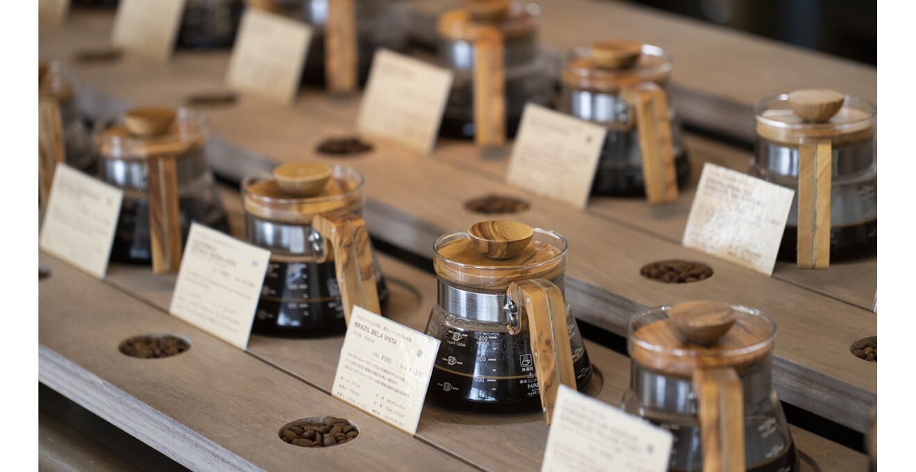 さまざまな豆と淹れたコーヒーが並んで展示している写真