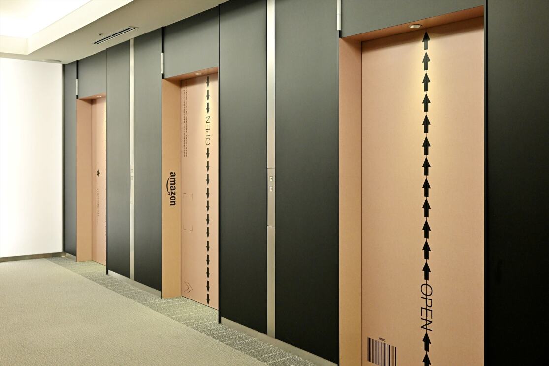 段ボールのデザインになっているエレベーターが3台並んでいる