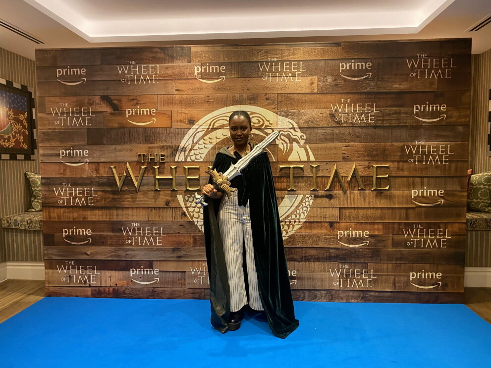 A fan in a green cloak holding a sword at wheel of time screening 