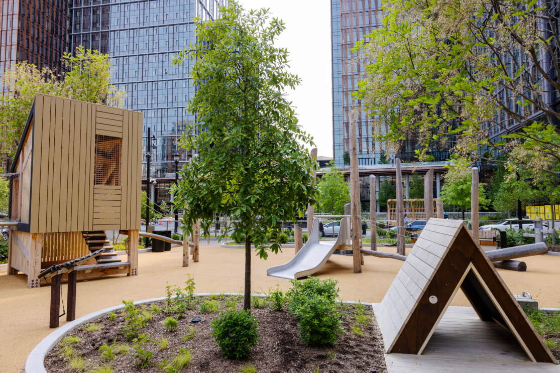 A photo of a children's park that has a slide, treehouse, and other play equipment, located at Metropolitan Park in Arlington, Virginia, next to Amazon HQ2. 