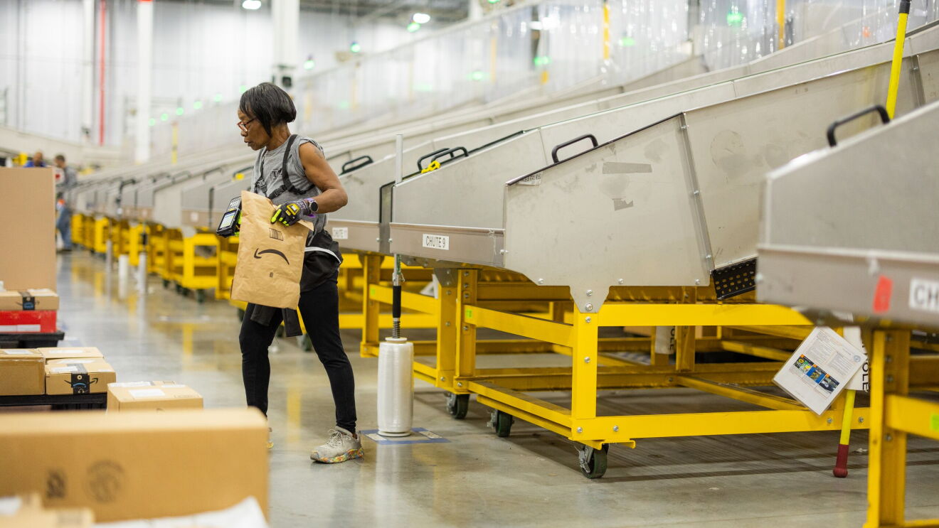Amazon employee in a fulfillment center sorting packages