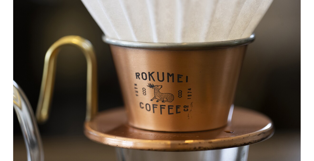鹿とロゴが刻印されている銅製のコーヒードリッパーの写真