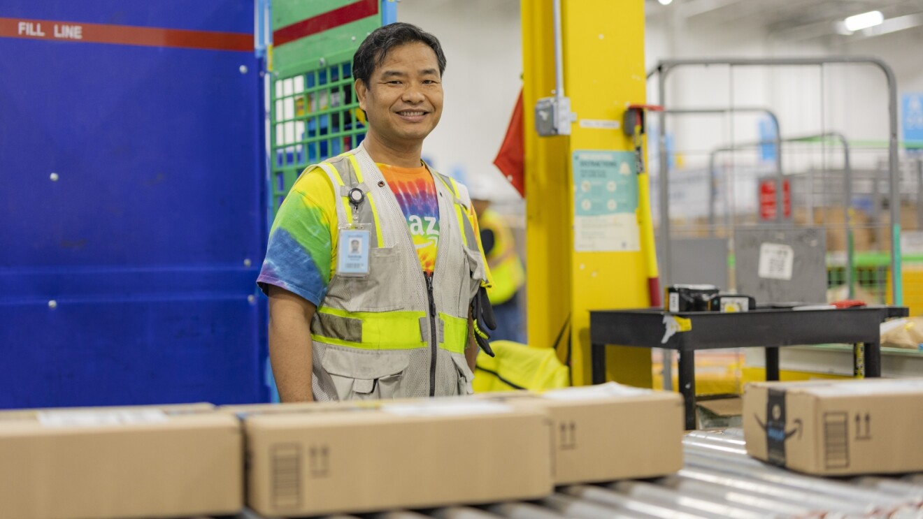 Amazon employee smiling in colorful shirt and safety vest