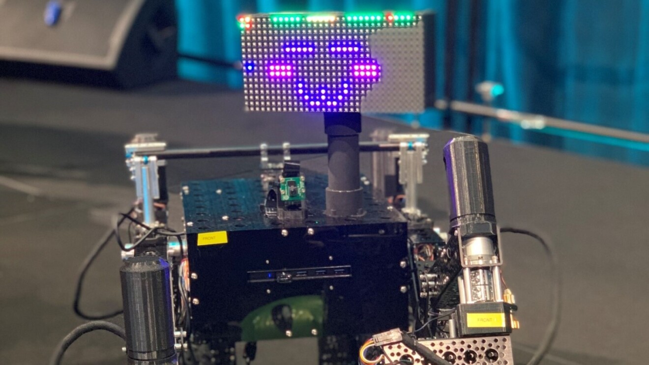 A small robot with wheel feet and an LED face