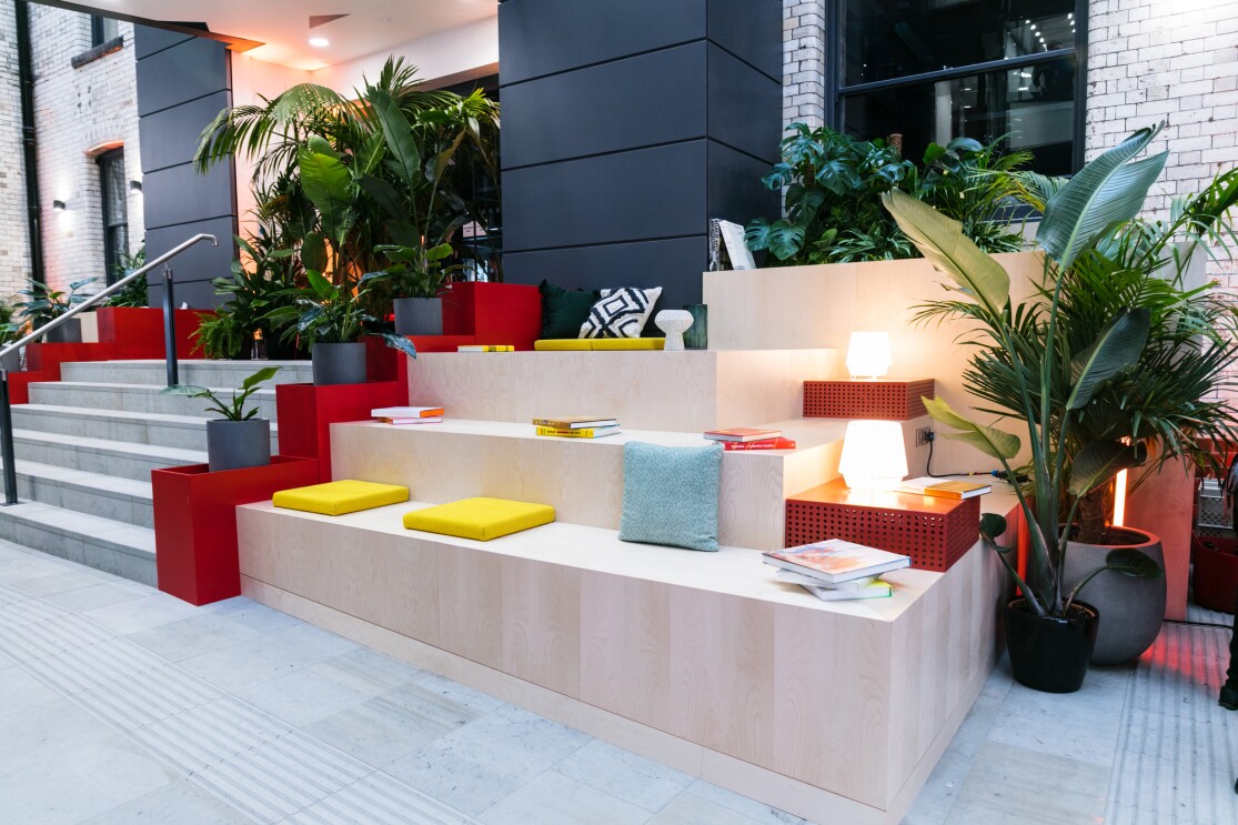 Minimalist seating area surrounded by potted plants and warm lighting