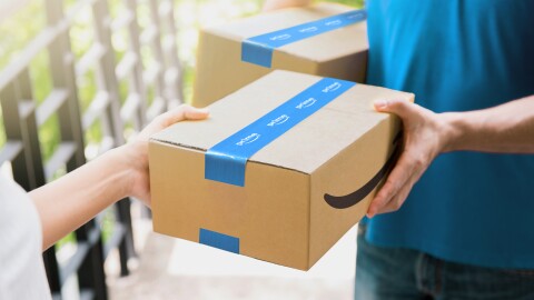 An Amazon parcel is handed to a Prime customer
