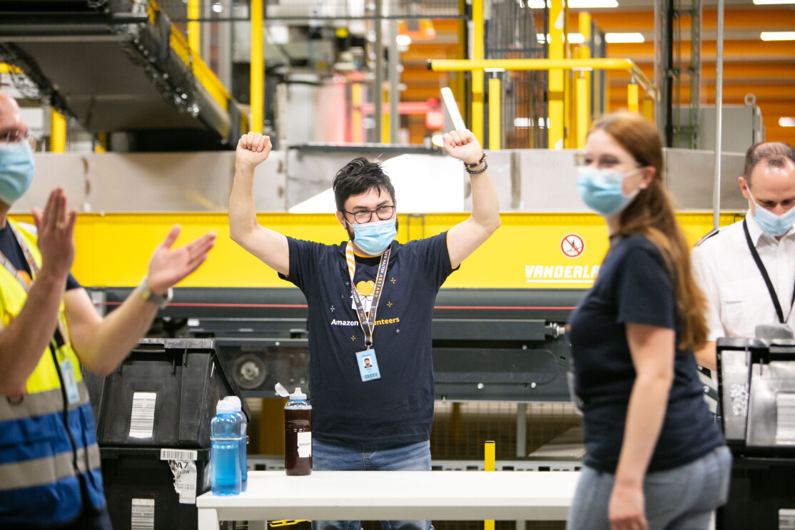 Amazon Mitarbeiter mit Mundschutz und T-Shirt mit Aufschrift "Amazon Volunteers"