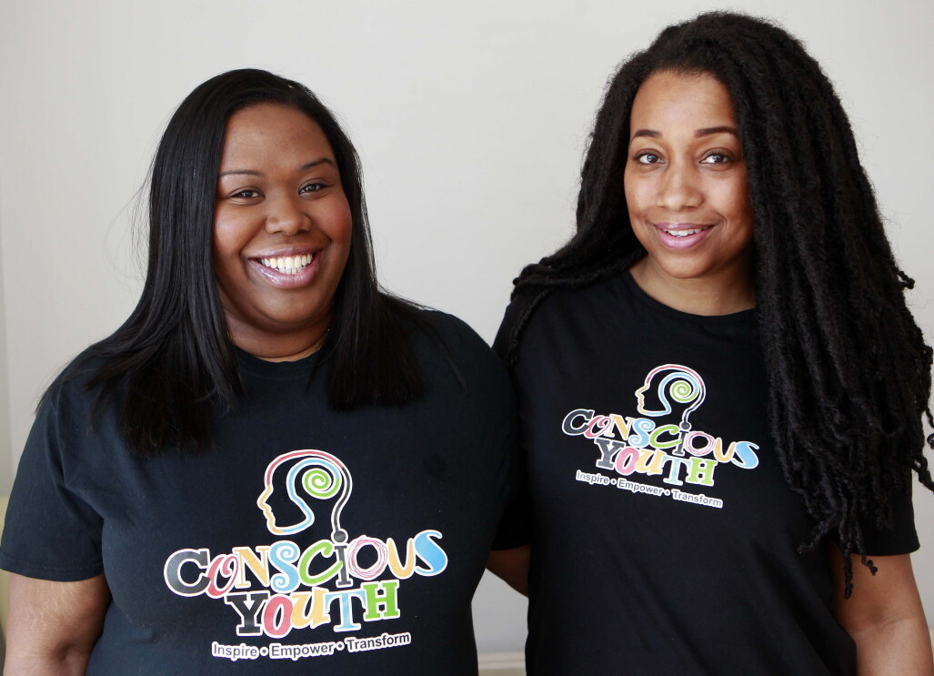 An image of Sophie and Serena from Conscious Youth, they are wearing t shirts with their logo on it. 
