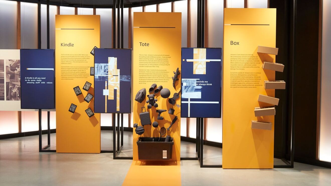 The exhibition centre showing three items important to the whole Amazon delivery process: Kindle, tote and packaging box.