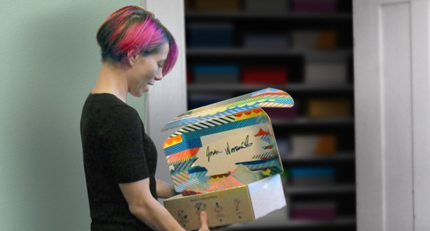 A woman is holding a new Amazon package that is designed to be reversible.