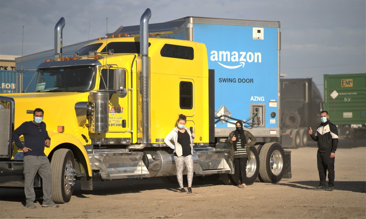 Amazon employees who work on the middle mile, posing for the camera at work