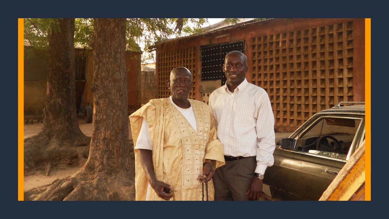 A photo of Alioune Thiam, senior systems engineer at AWS standing next to his father.