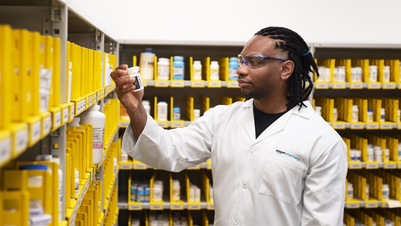 An Amazon Pharmacy employee looking for a medication in storage. 