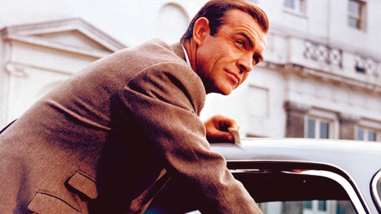 An image of the original James Bond movie character opening a car door and looking off into the distance.