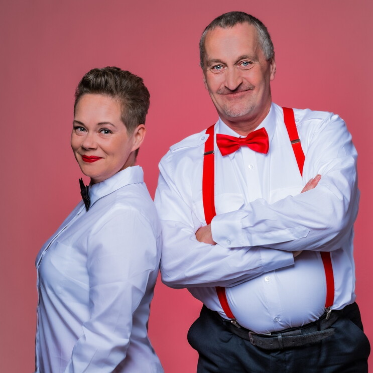 Ein Mann und eine Frau in weißen Hemden und mit Fliegen.