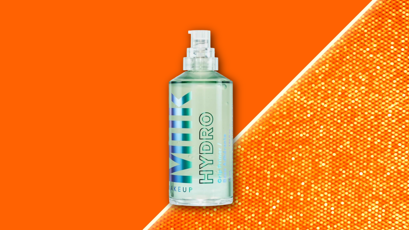 A bottle of hydrating face primer from Milk Makeup floating against a vibrant orange backdrop.