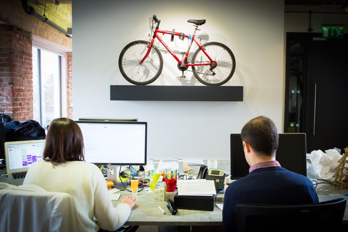 People sat at computers with a small bike in the foreground