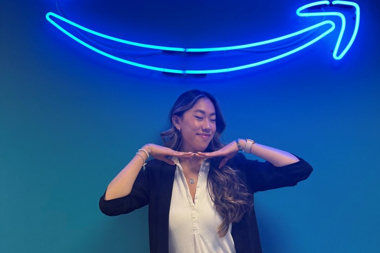 A young woman stands in front of the Prime sign