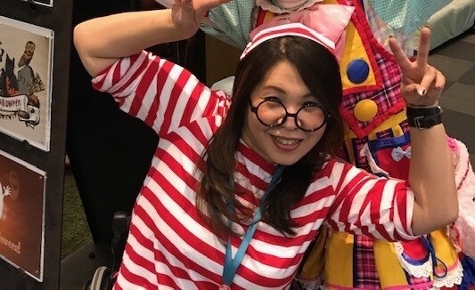 赤と白の縞模様のTシャツと帽子をかぶった笑顔の女性