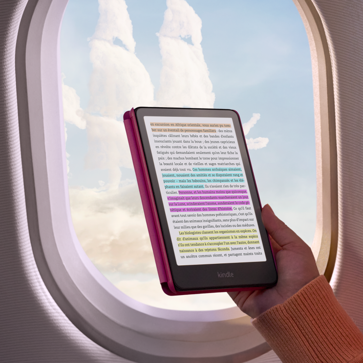 Mains tenant une liseuse Kindle affichant du texte en français avec du texte surligné en couleur