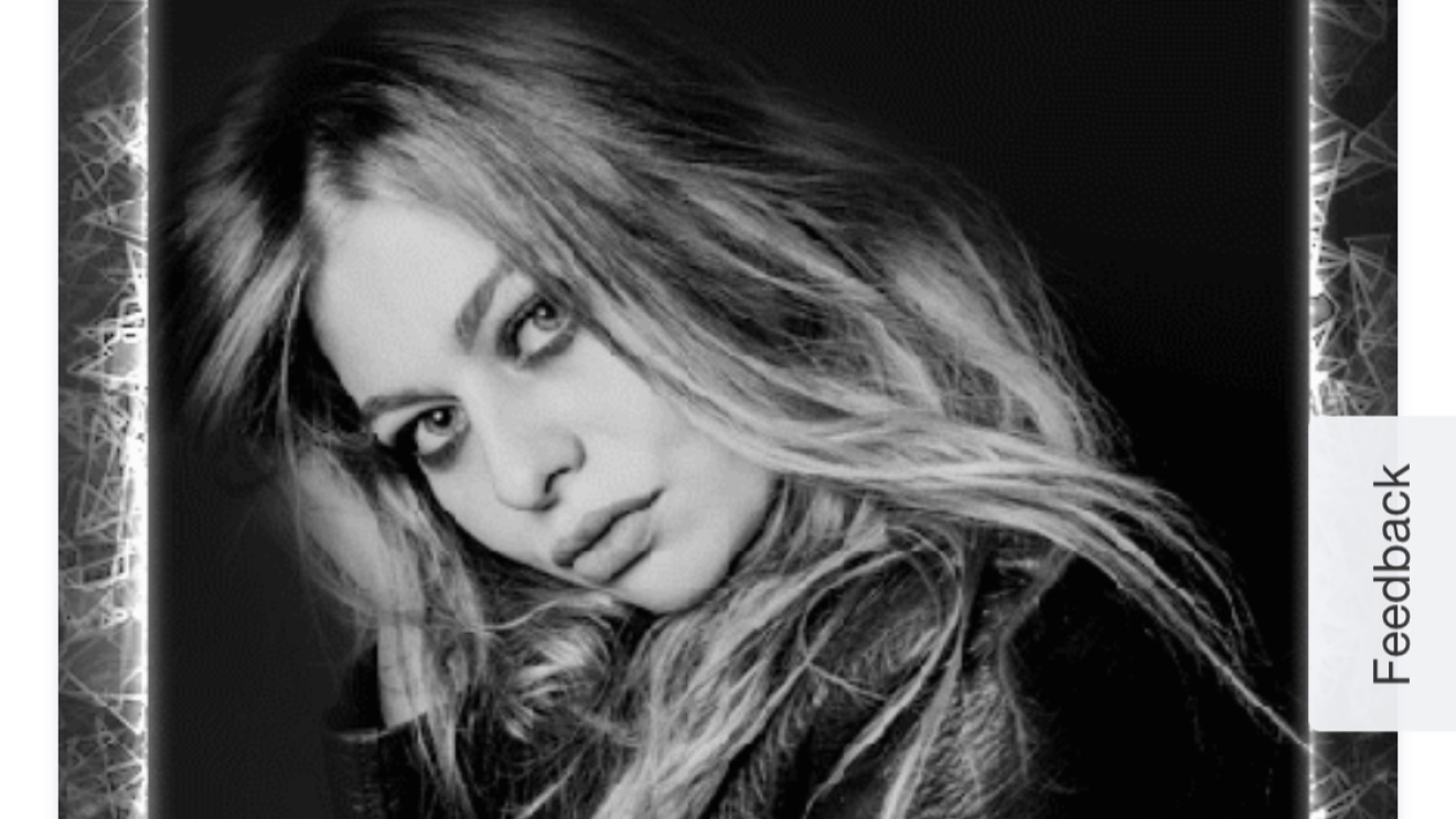 Schwarz-weiß Bild von Sängerin Zoe. Sie hält den Kopf nach vorne geneigt und blickt in die Kamera, Screenshot des NFTs zum Song Loin d'ici, von der Webseite von Global Rockstar.