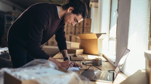 homme penché sur un bureau avec des boîtes en arrière-plan