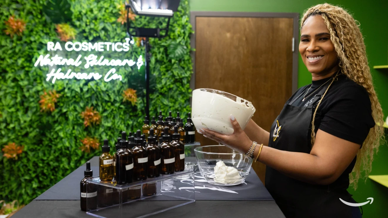 Adia Howard, COO of RA Cosmetics, mixing a beauty product surrounded by bottles of raw ingredients.