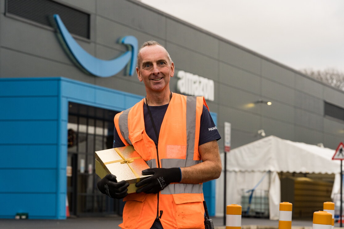 Phil Hayden holding a present outside his Amazon site