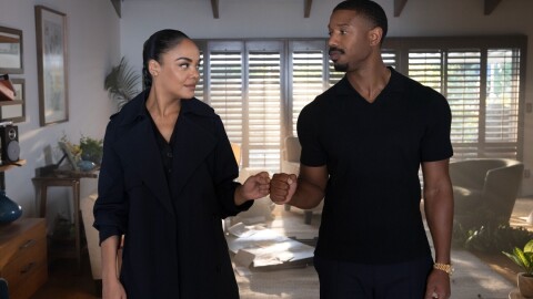 迈克尔·b·乔丹和特莎·汤普森都穿着黑色衣服,在一个家里互相碰了个拳。