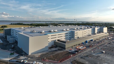 Aerial view of a large Amazon fulfilment centre with a blue sky backdrop