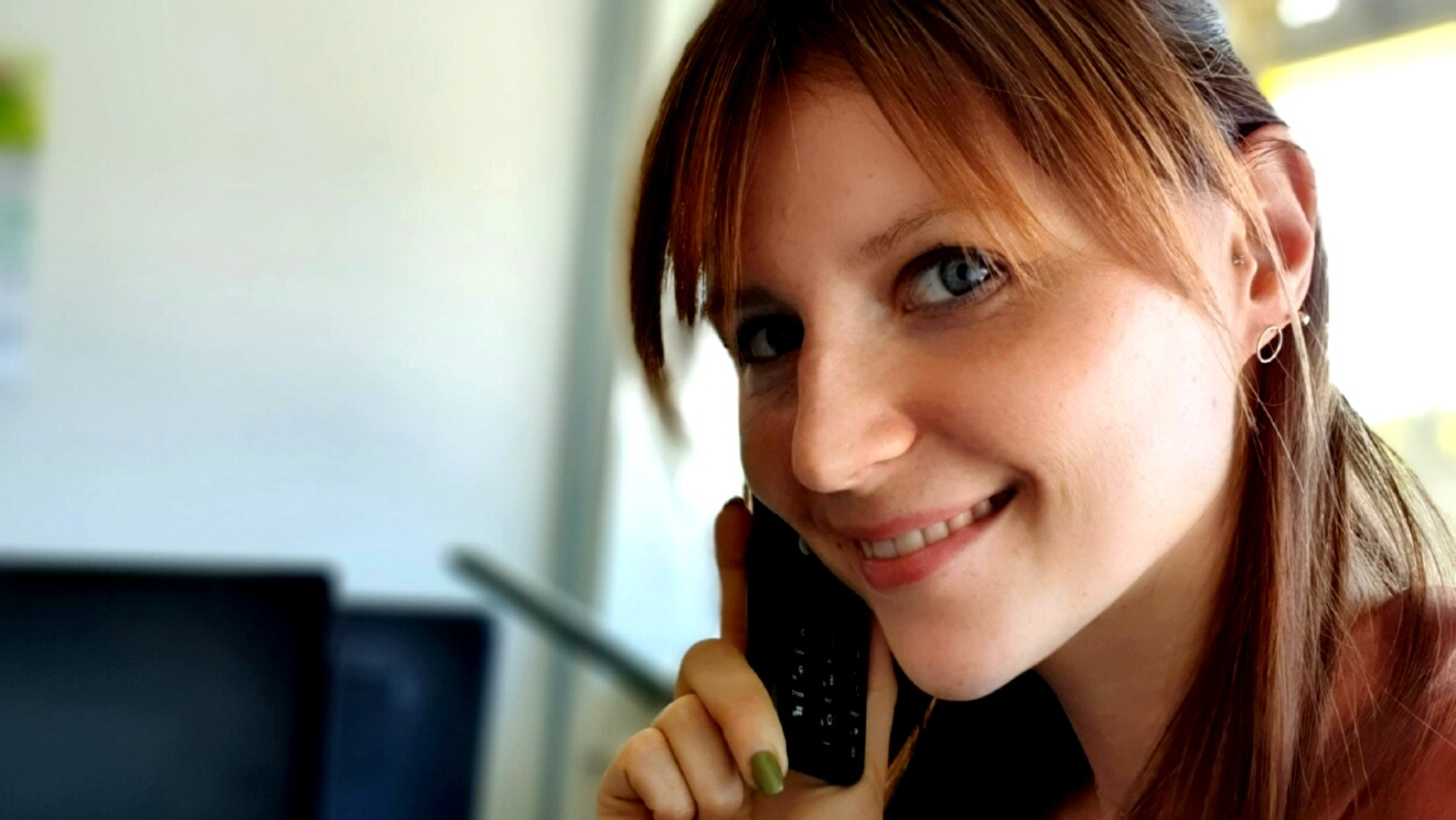 Eine junge Frau mit langen Haaren am Telefon
