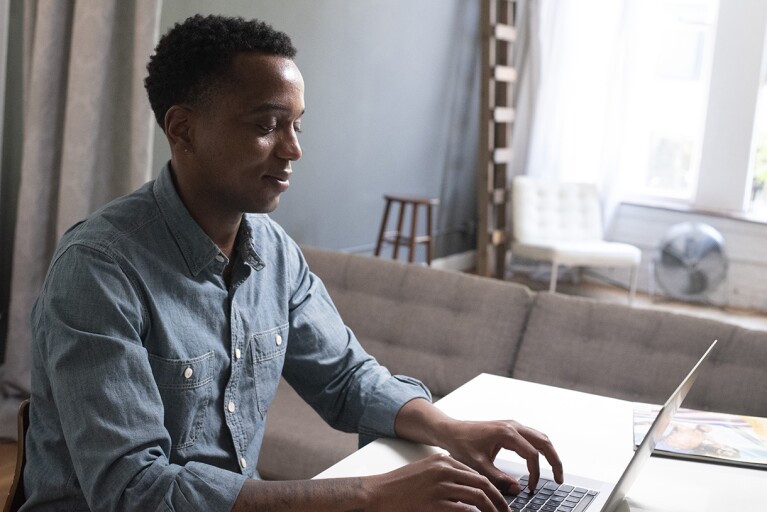 Amazon training program attendee sits at his desk and types on a laptop.