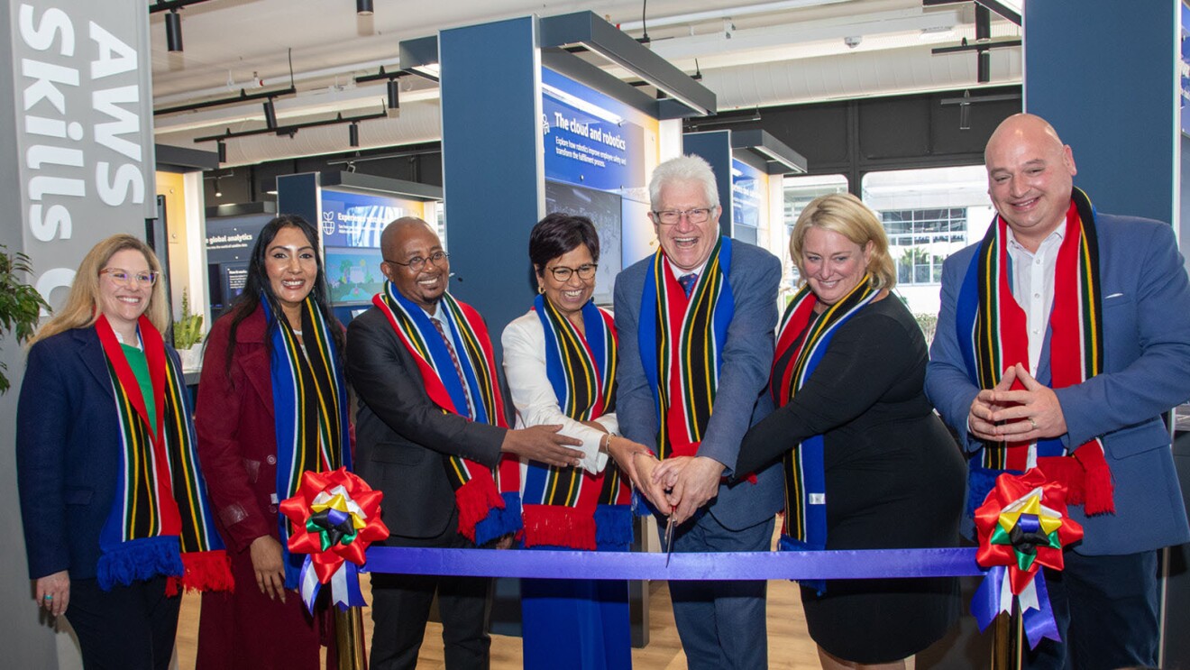 Members of the parliament in cape town south africa gathered around a ribbon about to cut it at the grand opening of the first international aws skills center