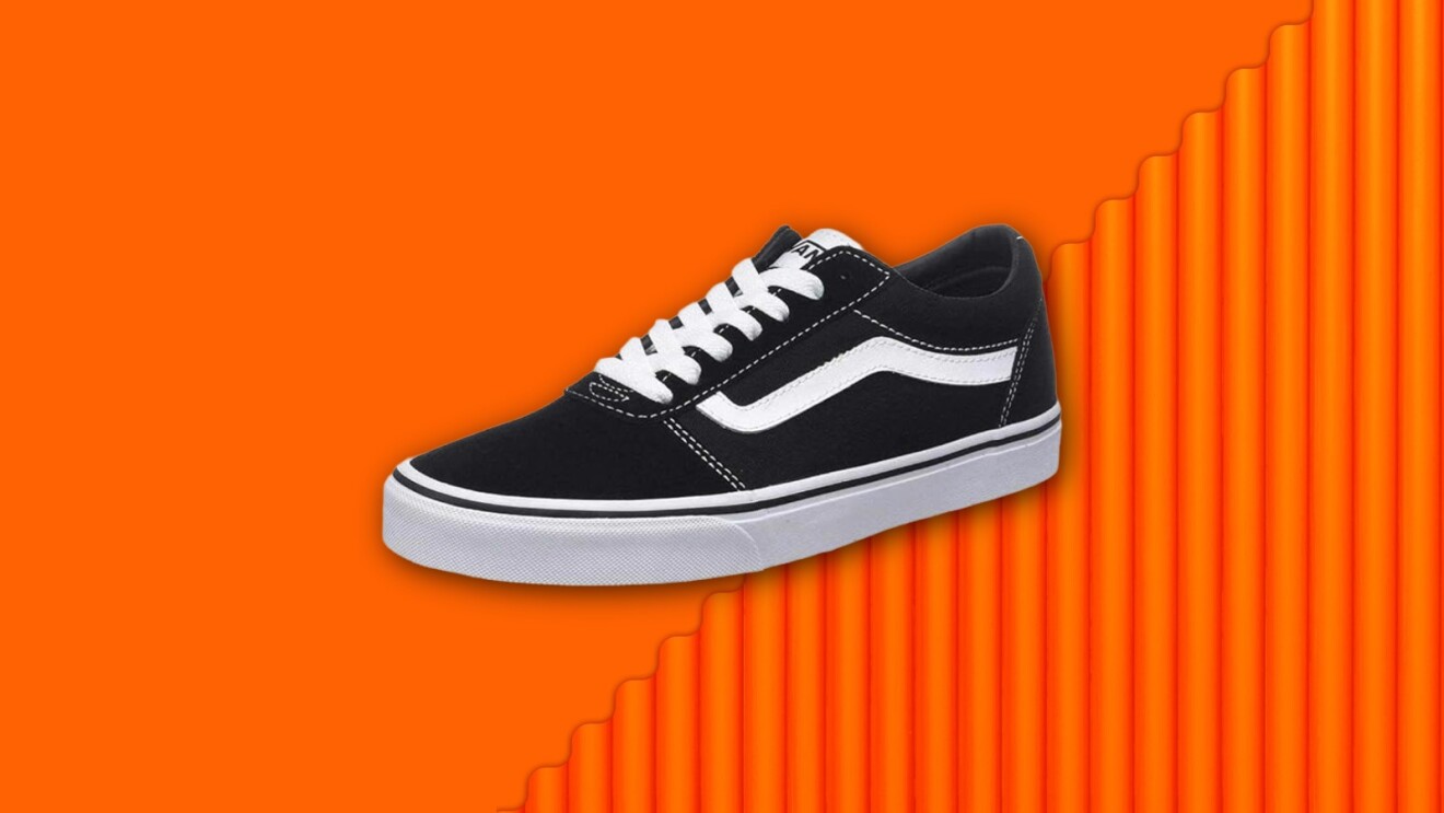 Classic black Vans sneaker with white stripe on vibrant orange background