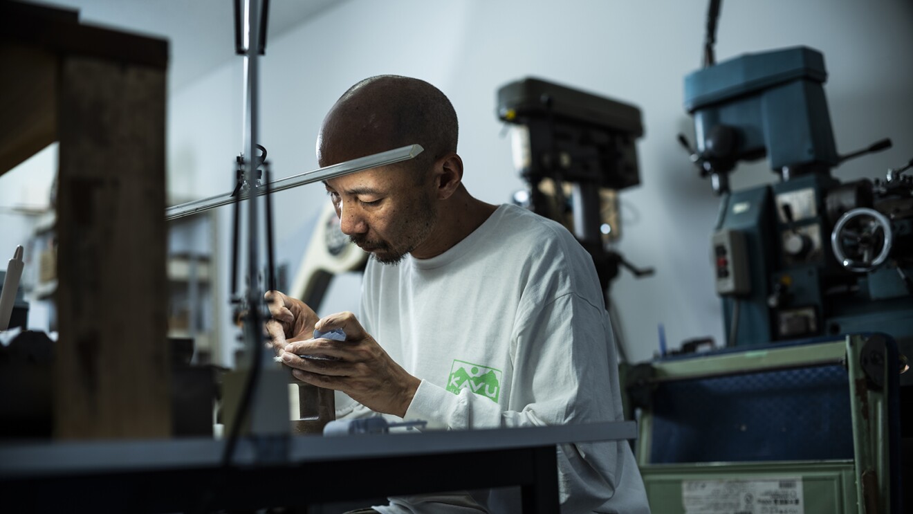 工具の前で真剣な表情で部品を組み立てている男性