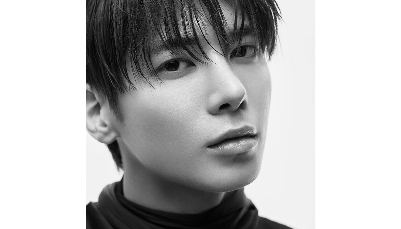 ショートカットの男性の顔をクローズアップで写したモノクロポートレート。