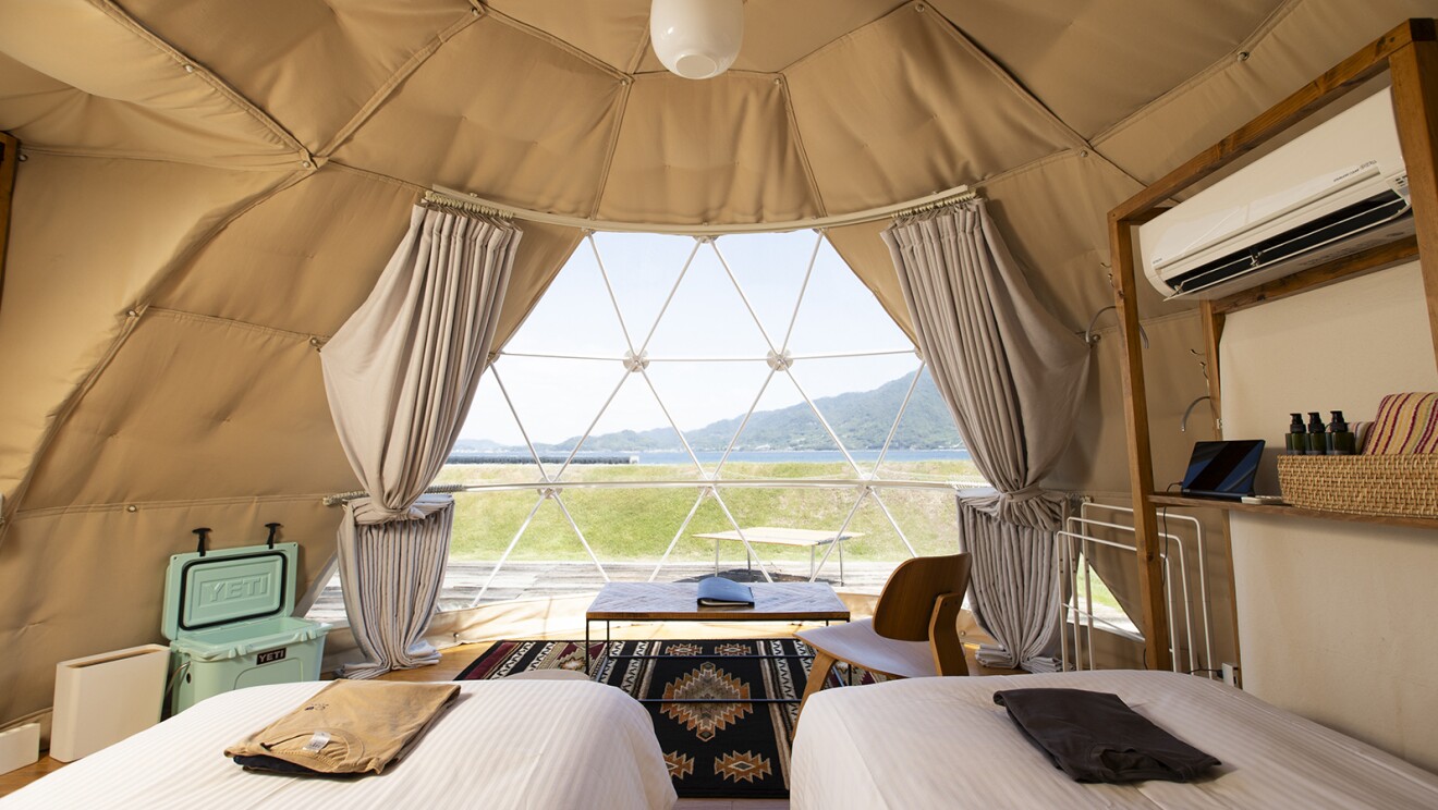 テント内部の様子。広く、ベッドとエアコンがあり、ガラス窓がついている。