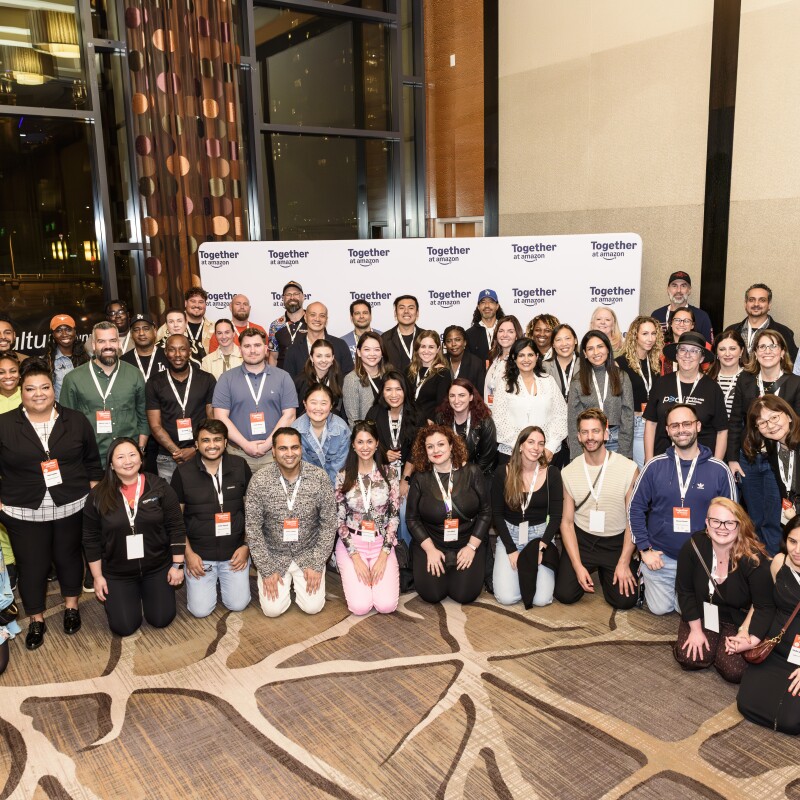 A large diverse group posing together at the 'Together at Amazon' event