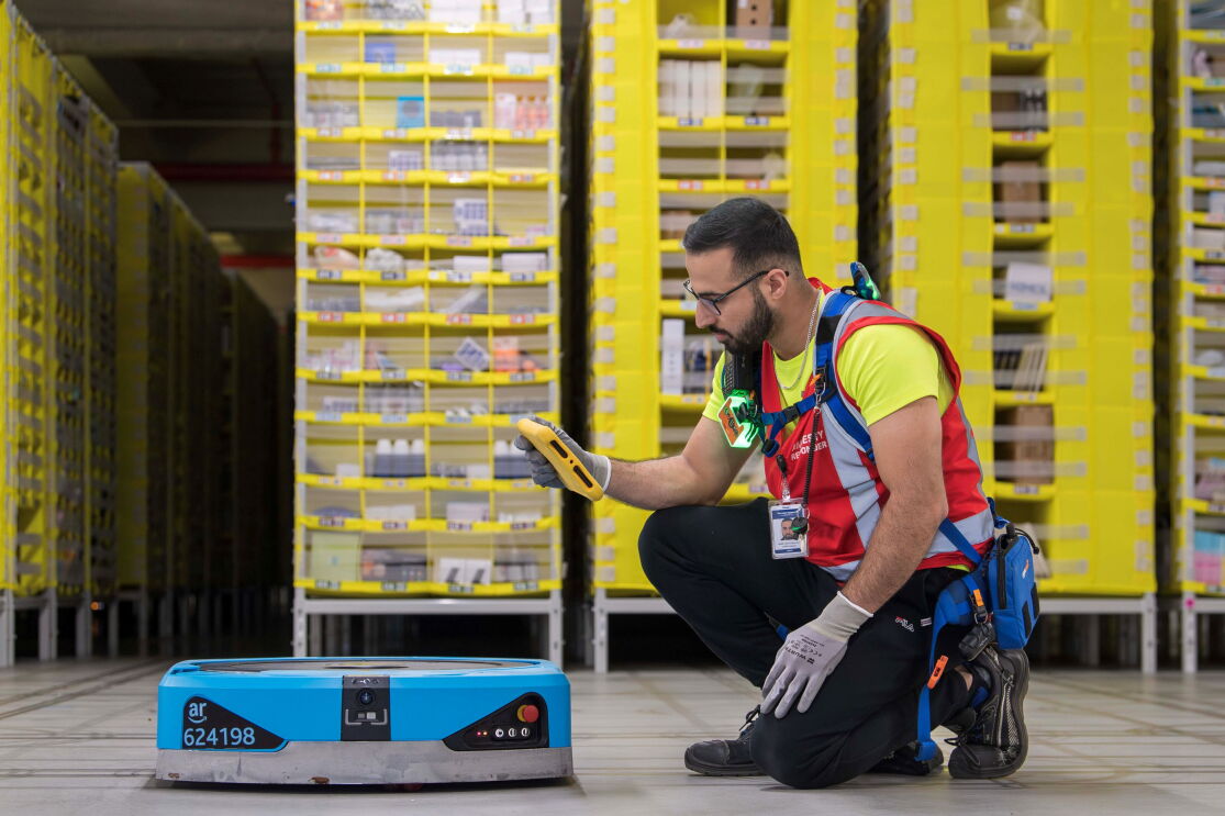 Amazon team member with robotic drive in a fulfilment centre