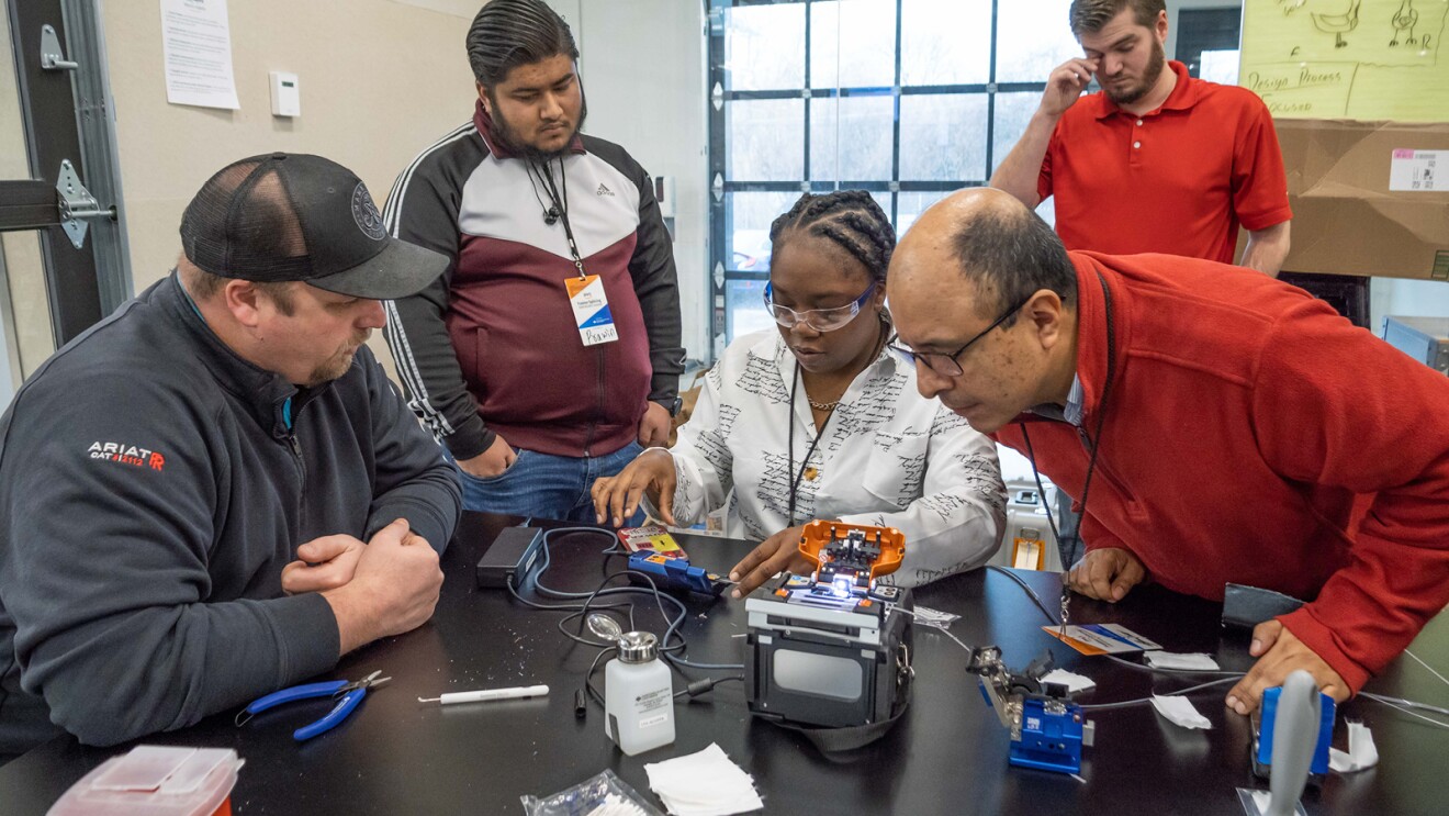 A photo of a student learning how to work on a fiber optic splicer in Ohio.