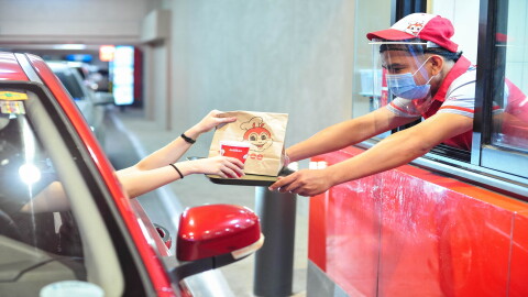 A customer going through a Jollibee drive-thru during the COVID pandemic.